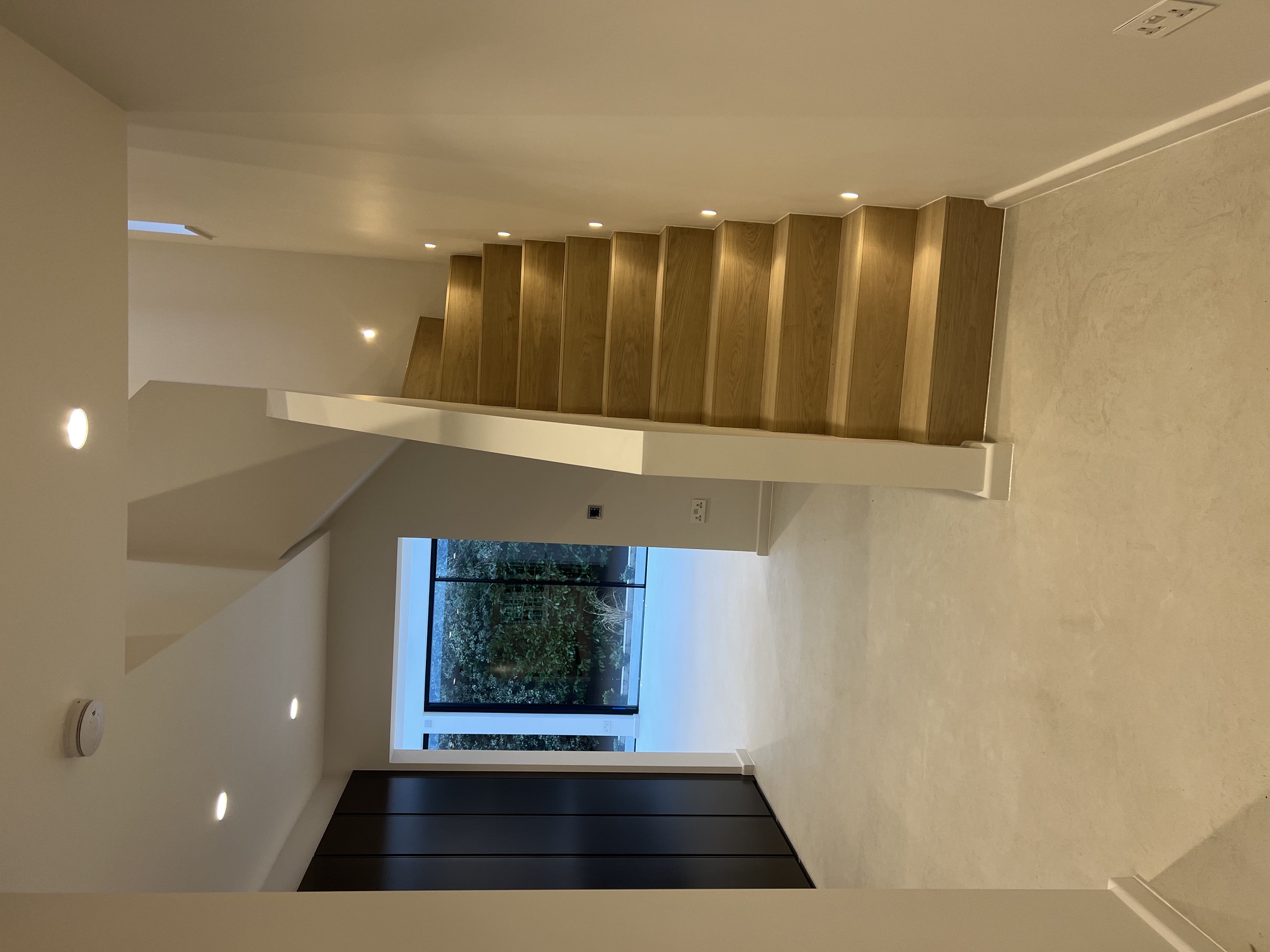 Refurbished hallway with oak staircase and microcement floor